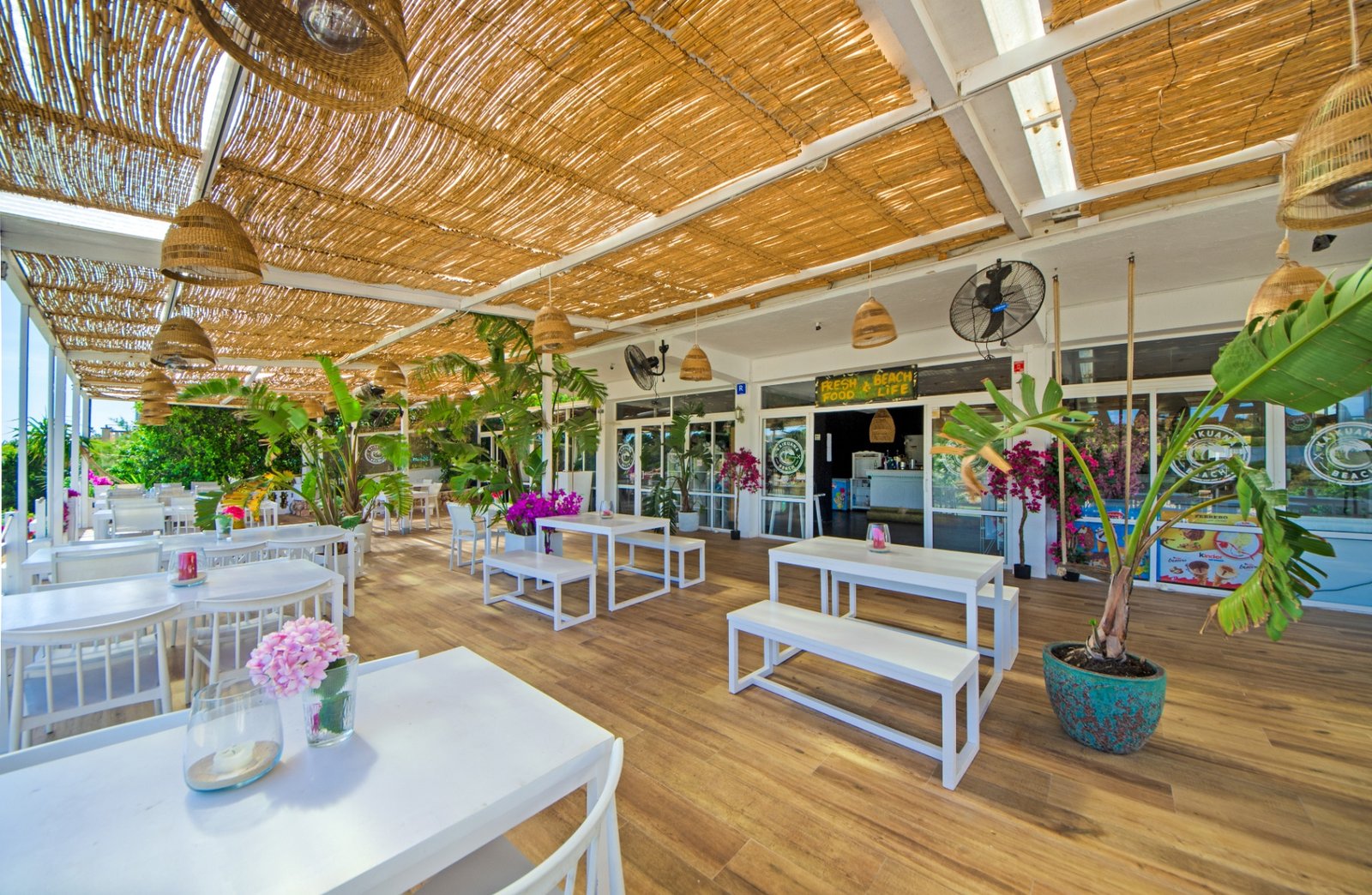 Interior del restaurante con mesas y vegetación